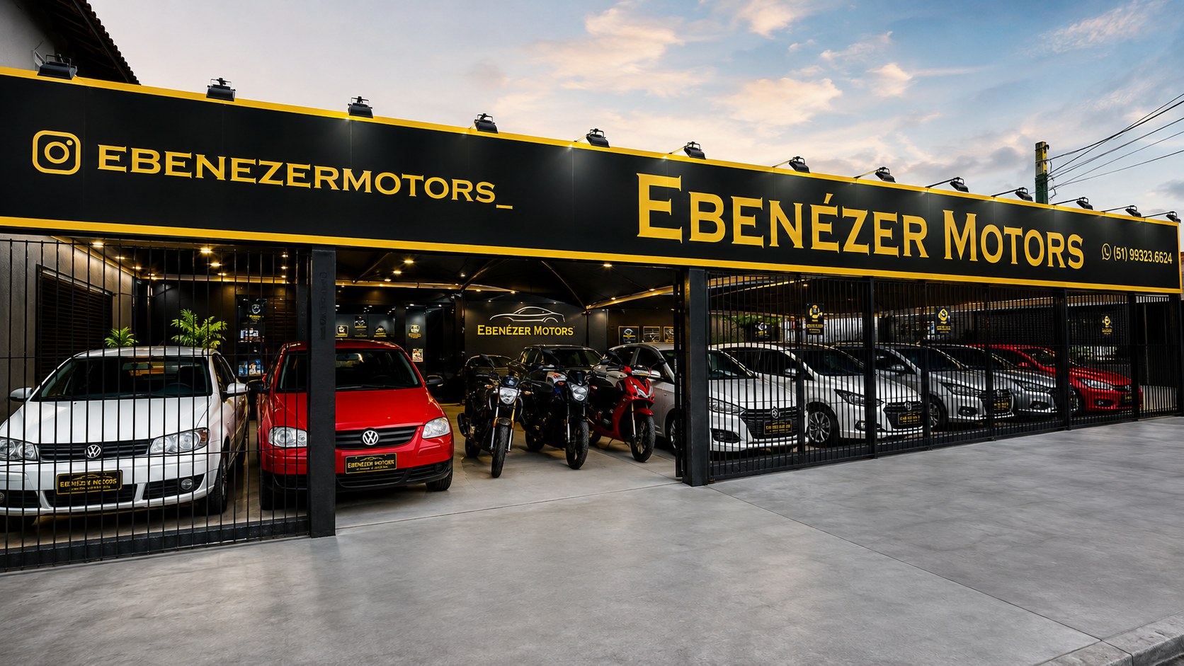 Fachada da Ebenézer Motors com veículos expostos ao anoitecer